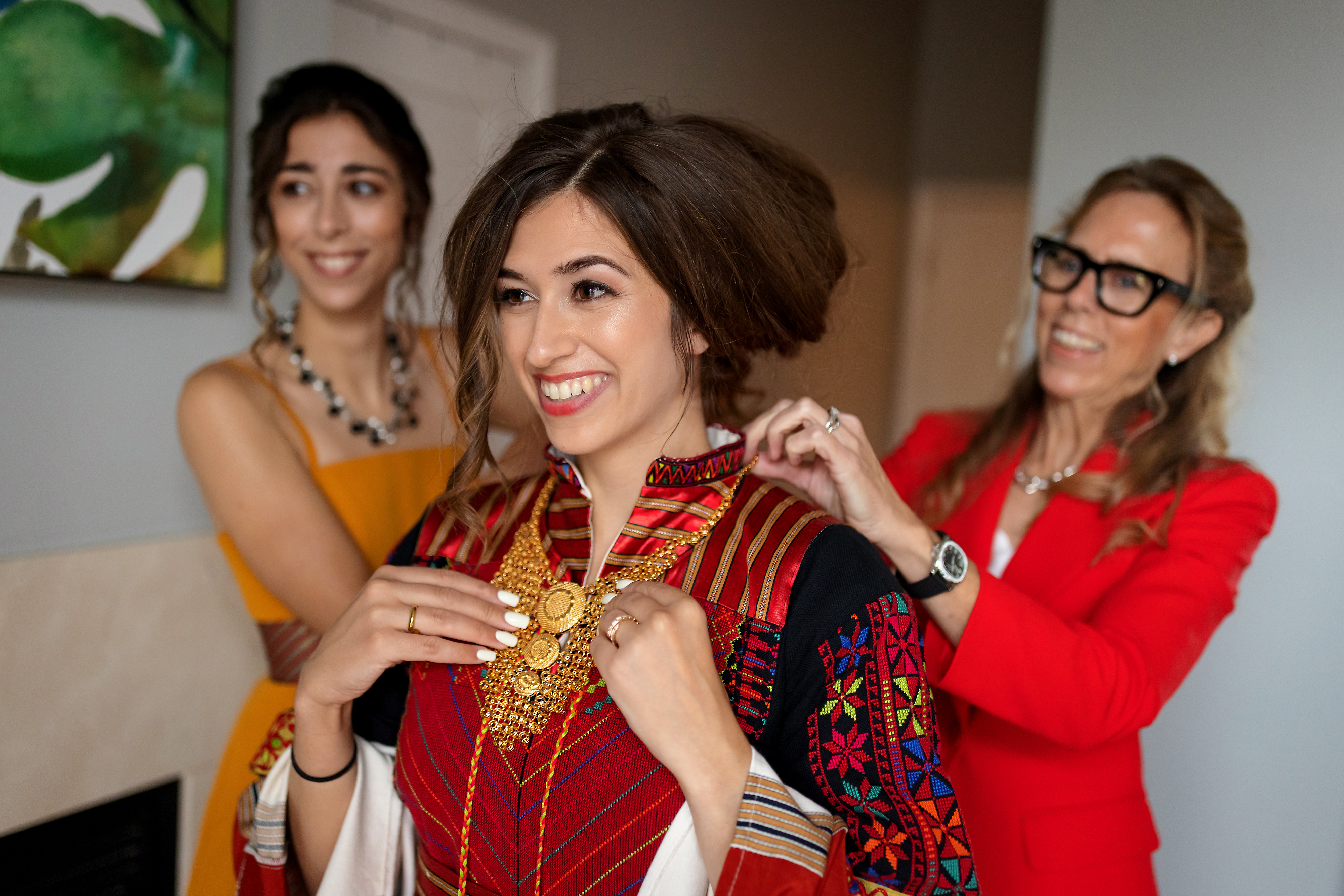Bride gets ready in traditional Palestinian bridal thobe with help from her sister and mother