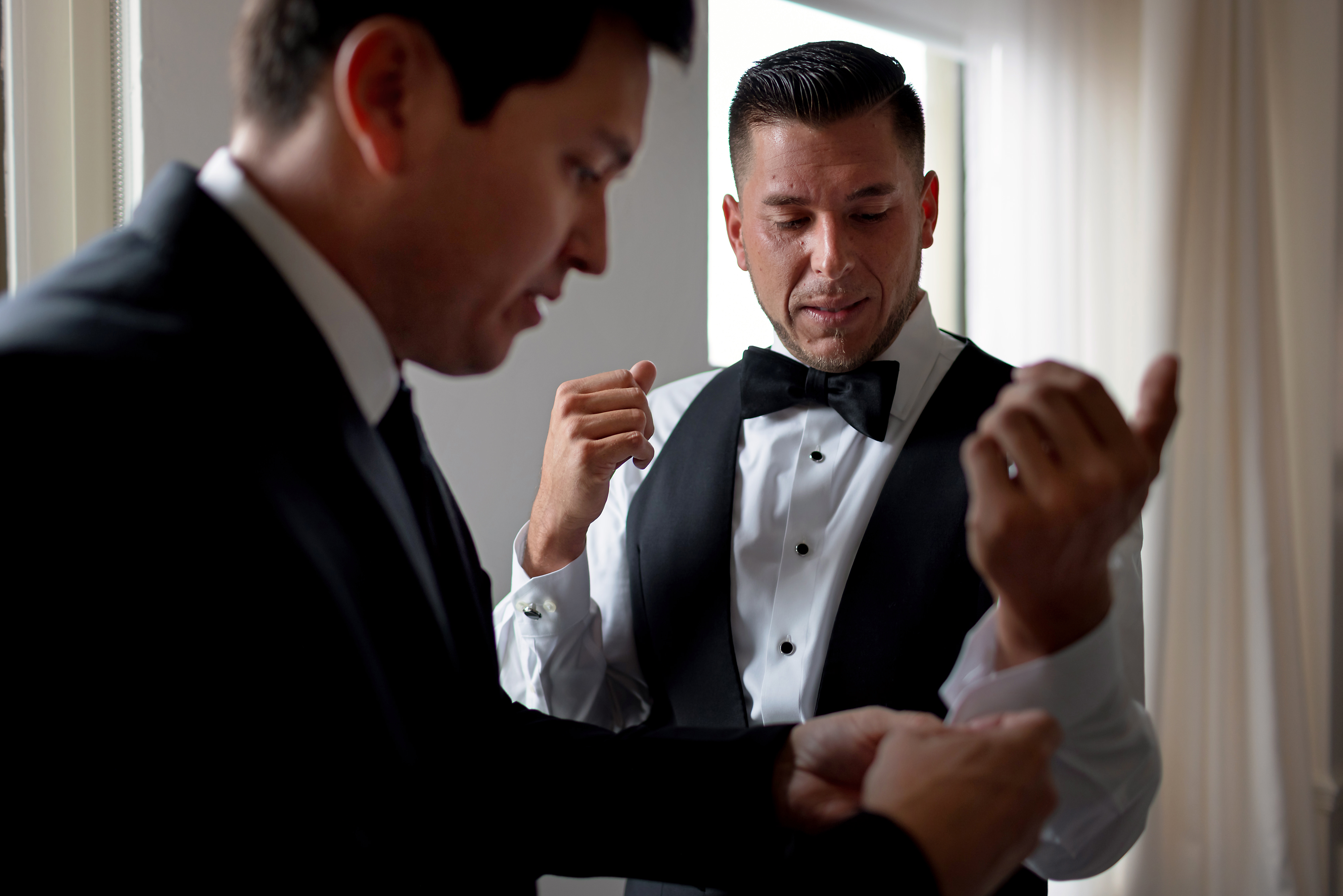 Groom and best man put on cuff links while getting ready for wedding at Ambassador Hotel Chicago.