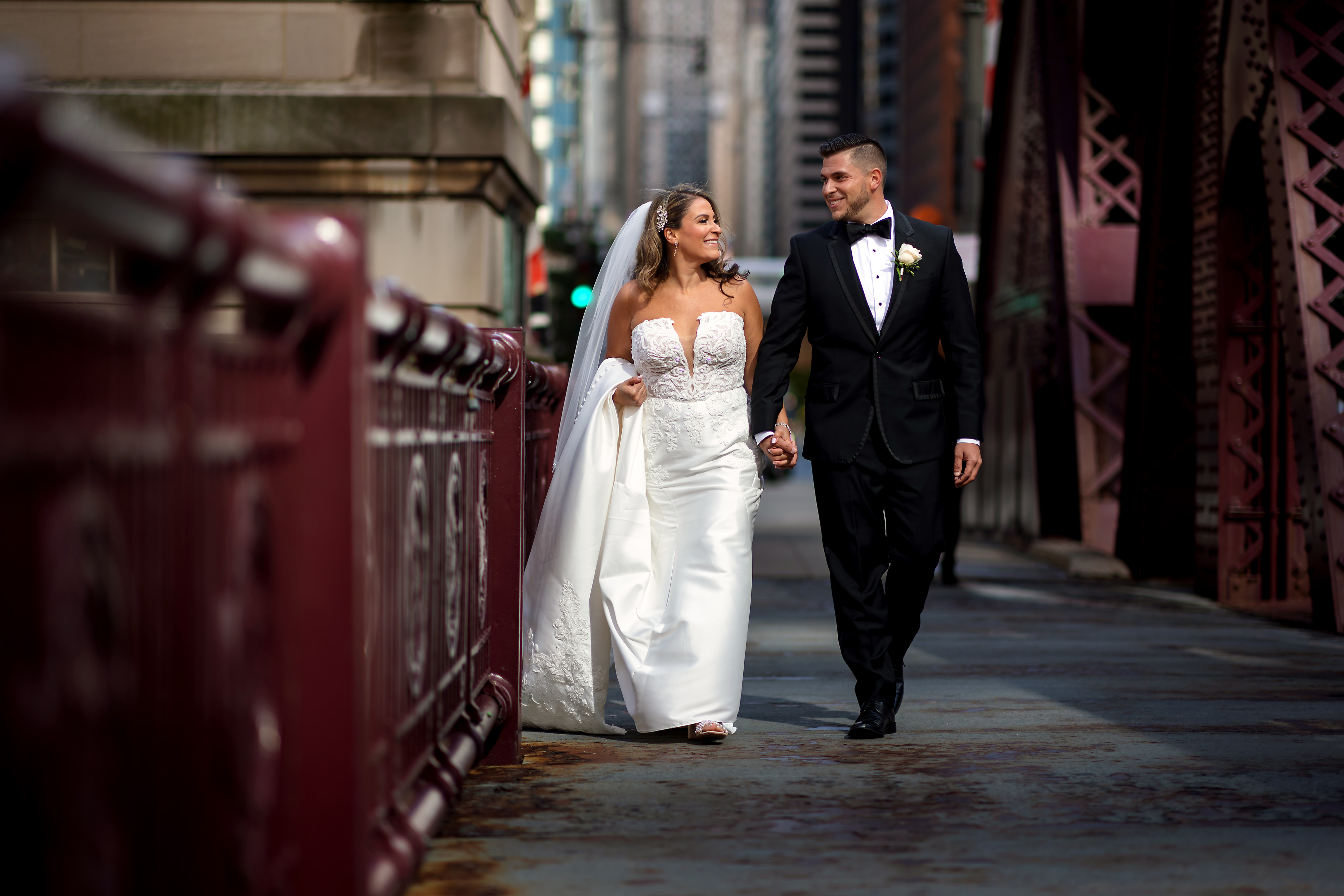 Bride and groom walk on LaSalle street in downtown Chicago during wedding portraits.