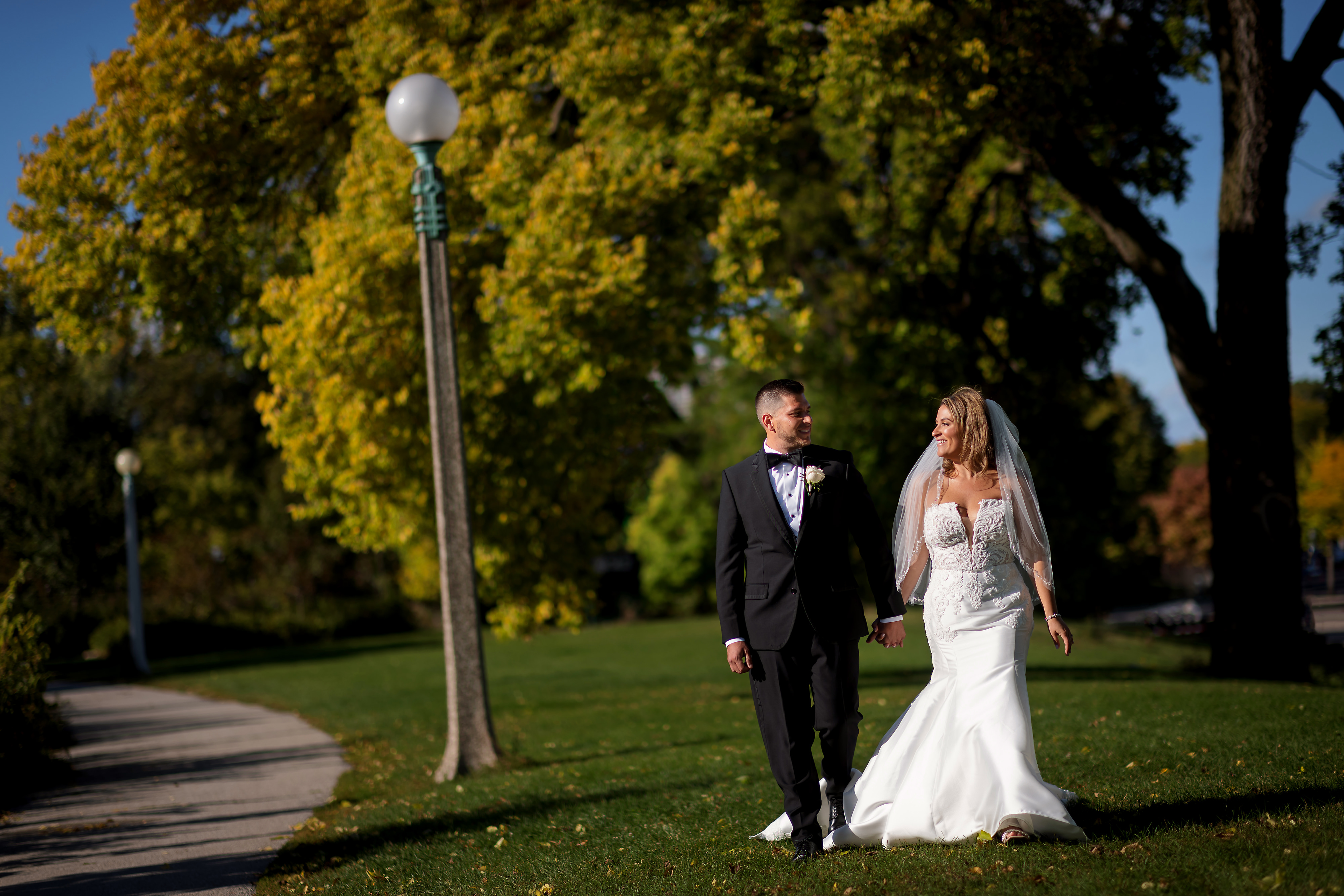 Bride and groom walk in Lincoln Park during wedding day portraits.