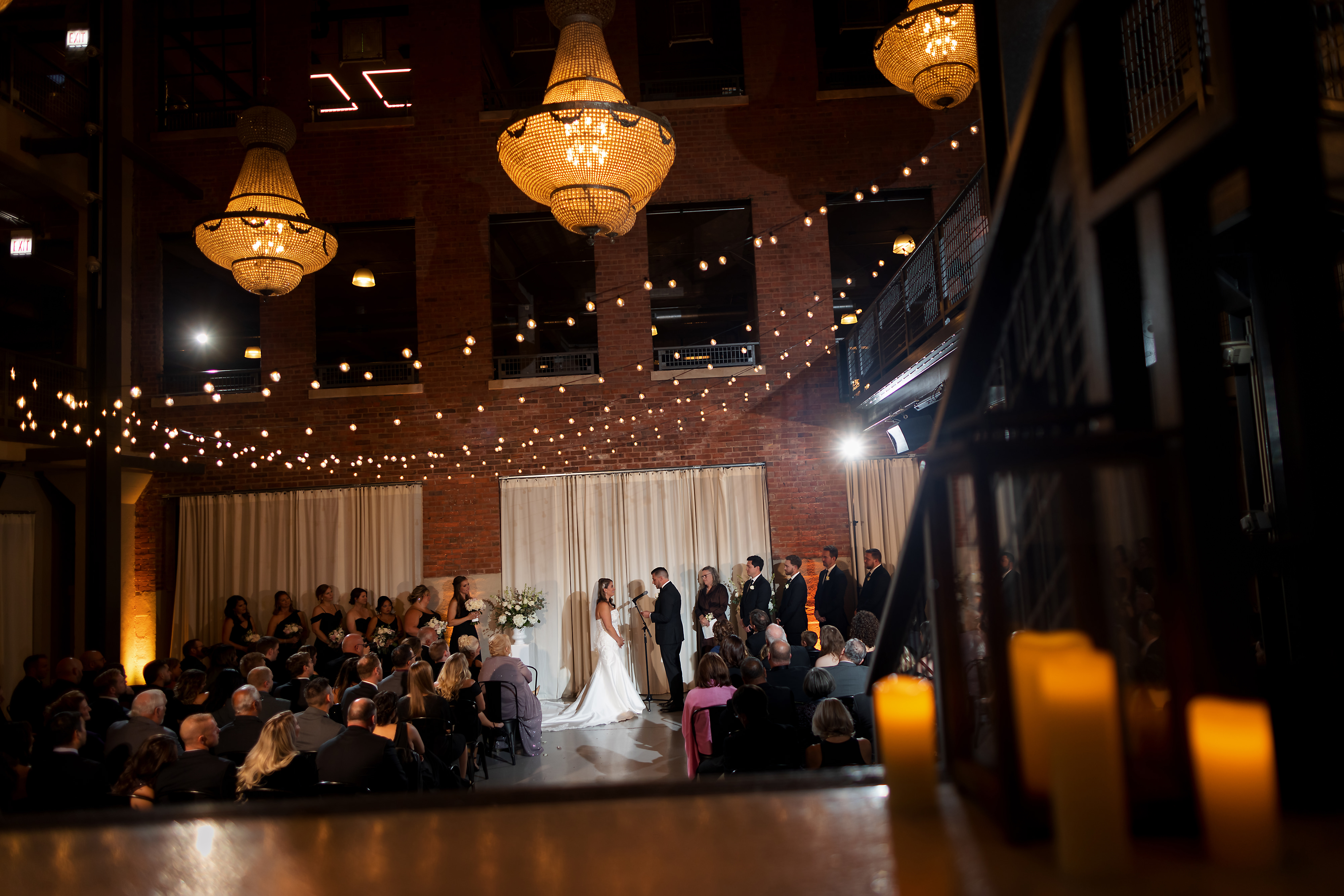 Wide angle view of North Atrium ceremony space with candles and chandeliers during wedding ceremony at Artifact Events in Chicago's Ravenswood neighborhood.