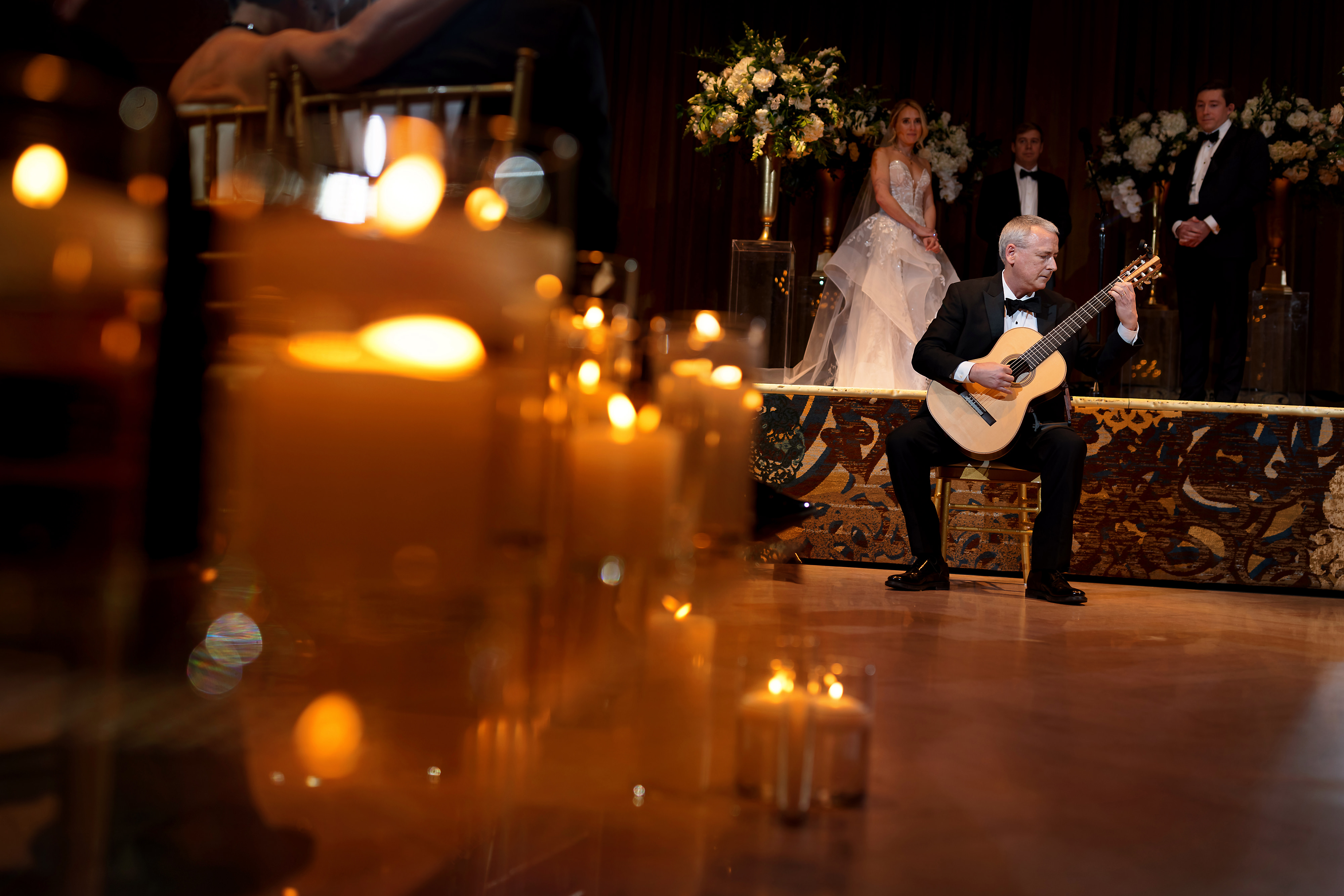Father of the bride plays guitar during wedding ceremony in the Grand Ballroom at The Drake Hotel in Chicago