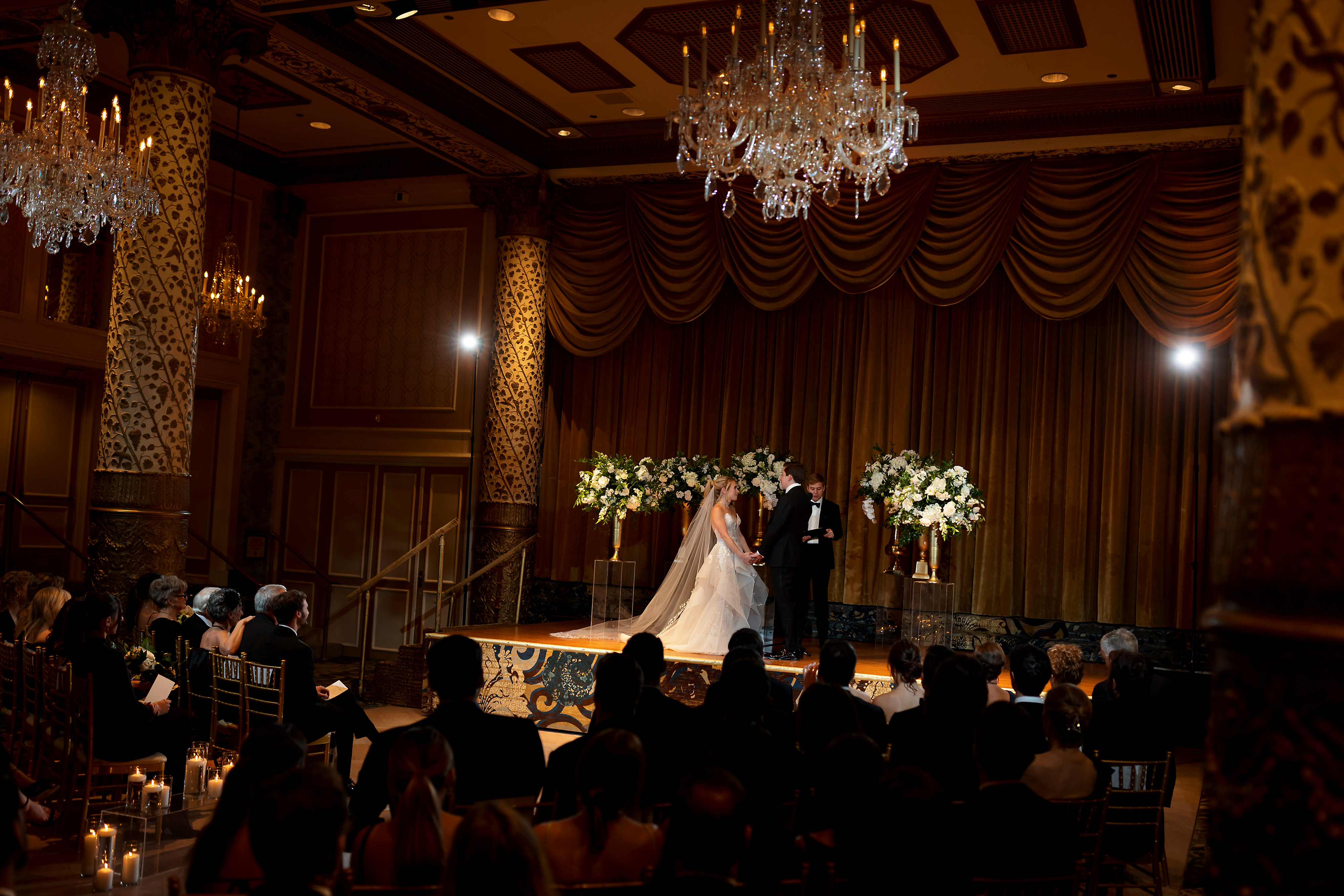Wide angle shot of stage and room during wedding ceremony in the Grand Ballroom at The Drake Hotel in Chicago
