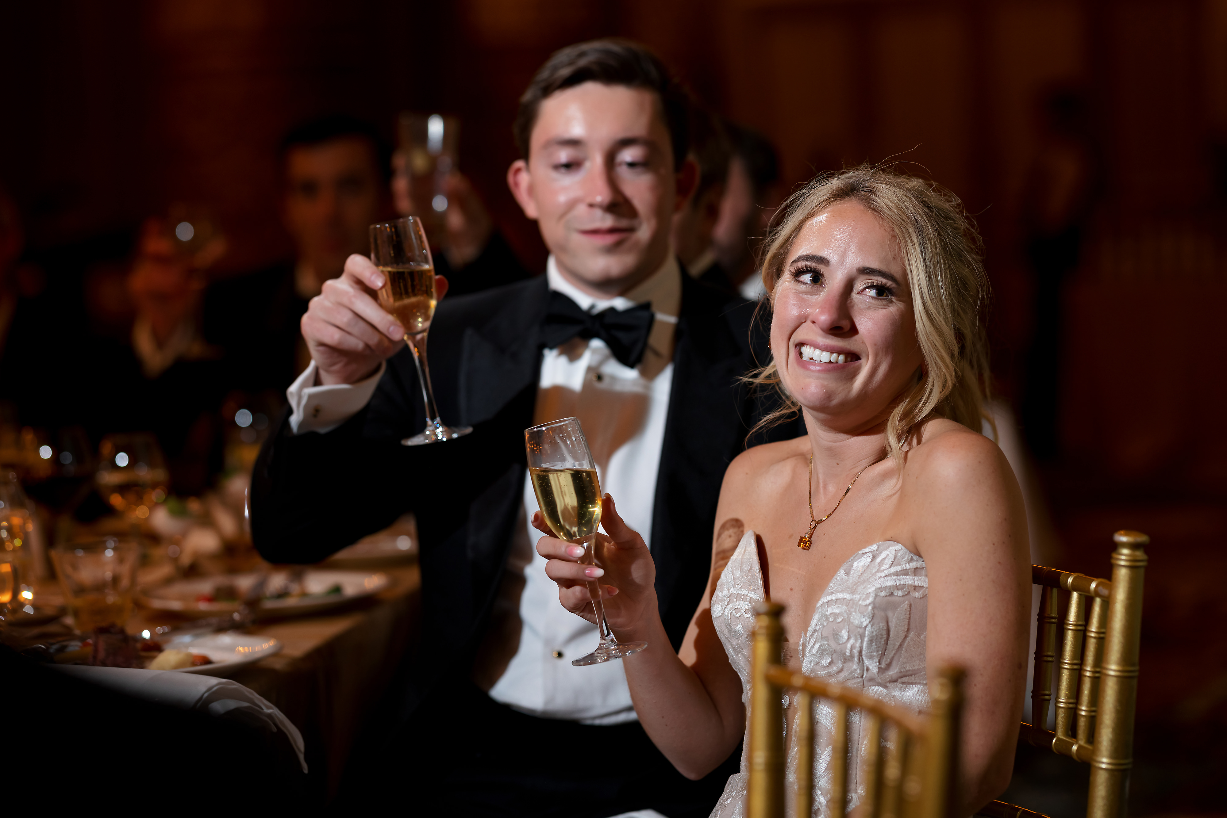 Bride and groom react to toast during wedding reception in the Grand Ballroom at The Drake Hotel in Chicago
