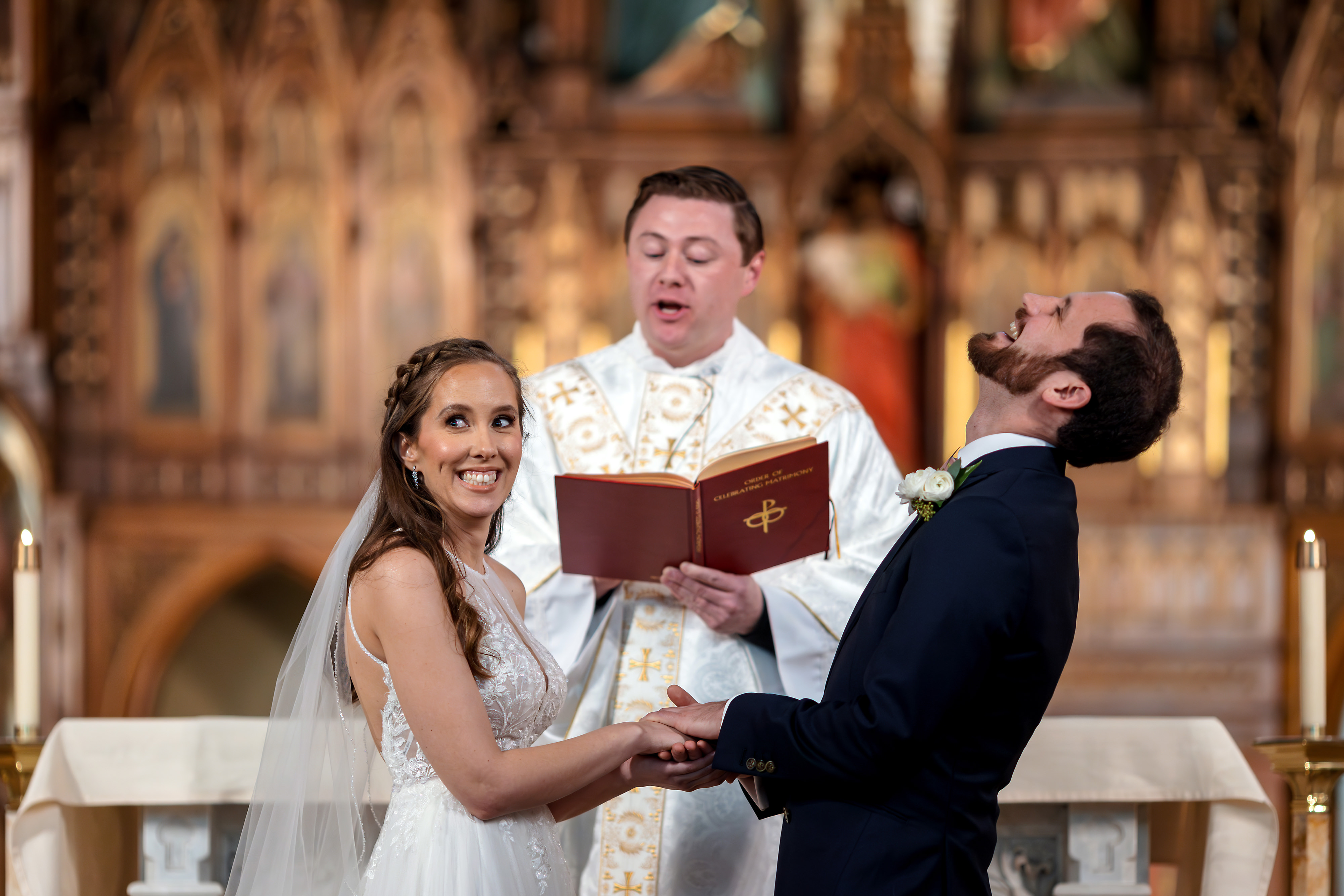 Bride and groom laugh while exchanging vows during wedding ceremony at  St. Joseph Catholic Church in Chicago