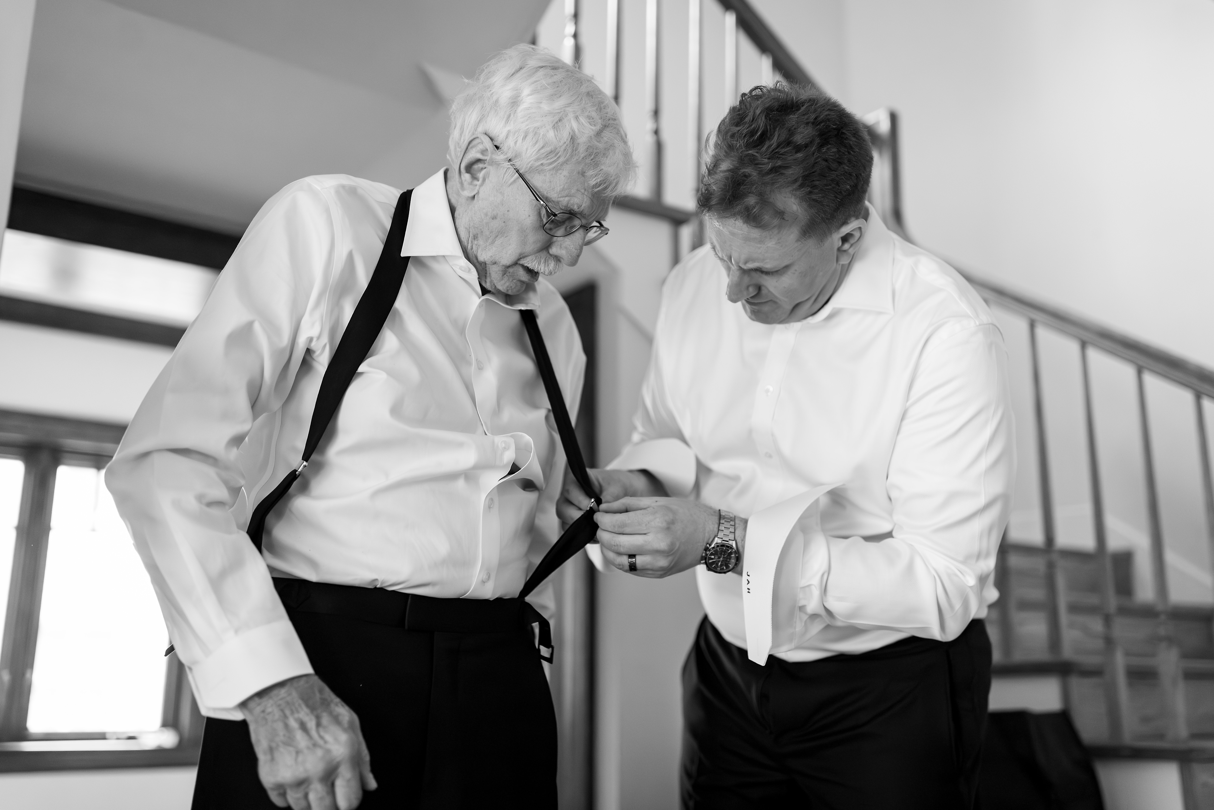 Groom helps father with suspenders