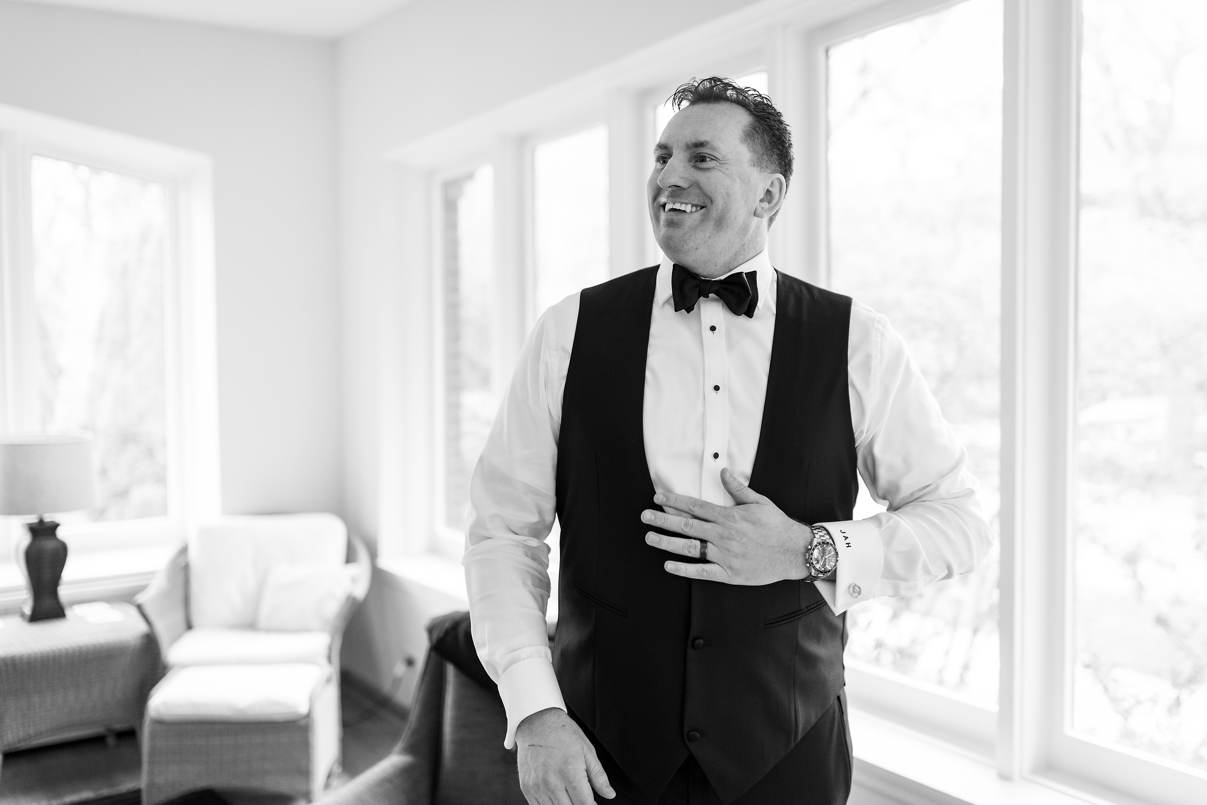 Groom laughs while getting ready for wedding