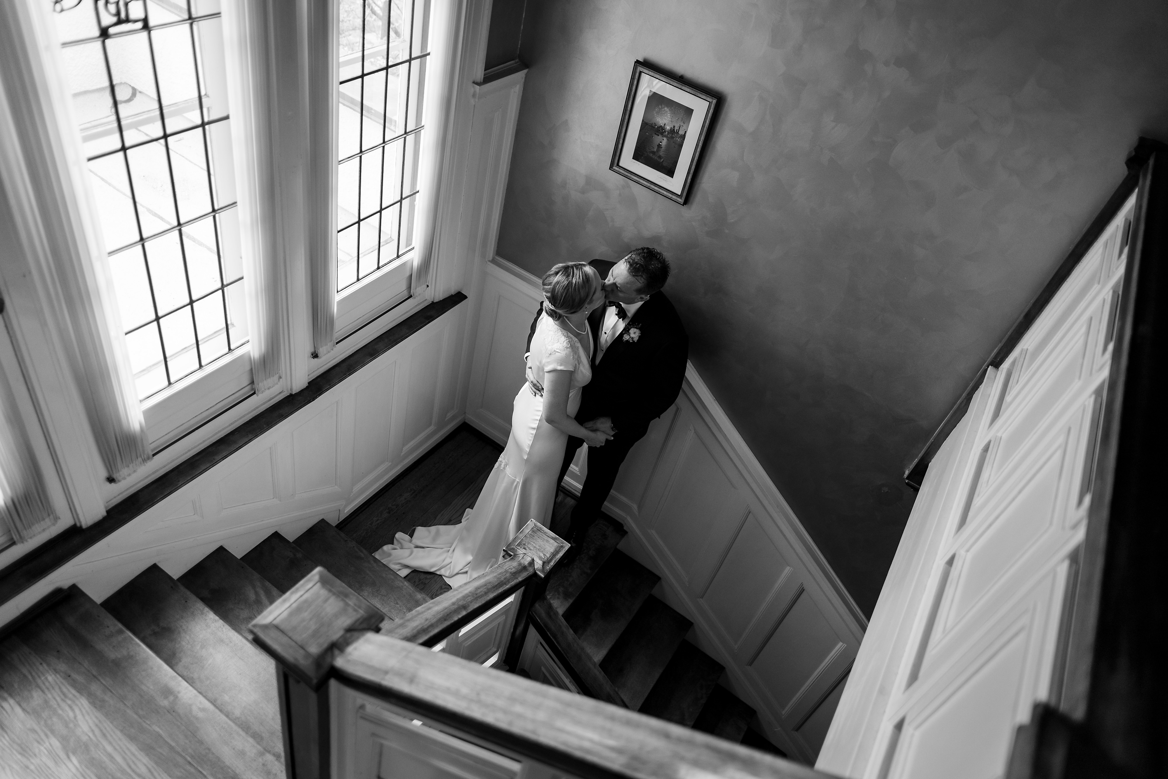 Bride and groom kiss on staircase