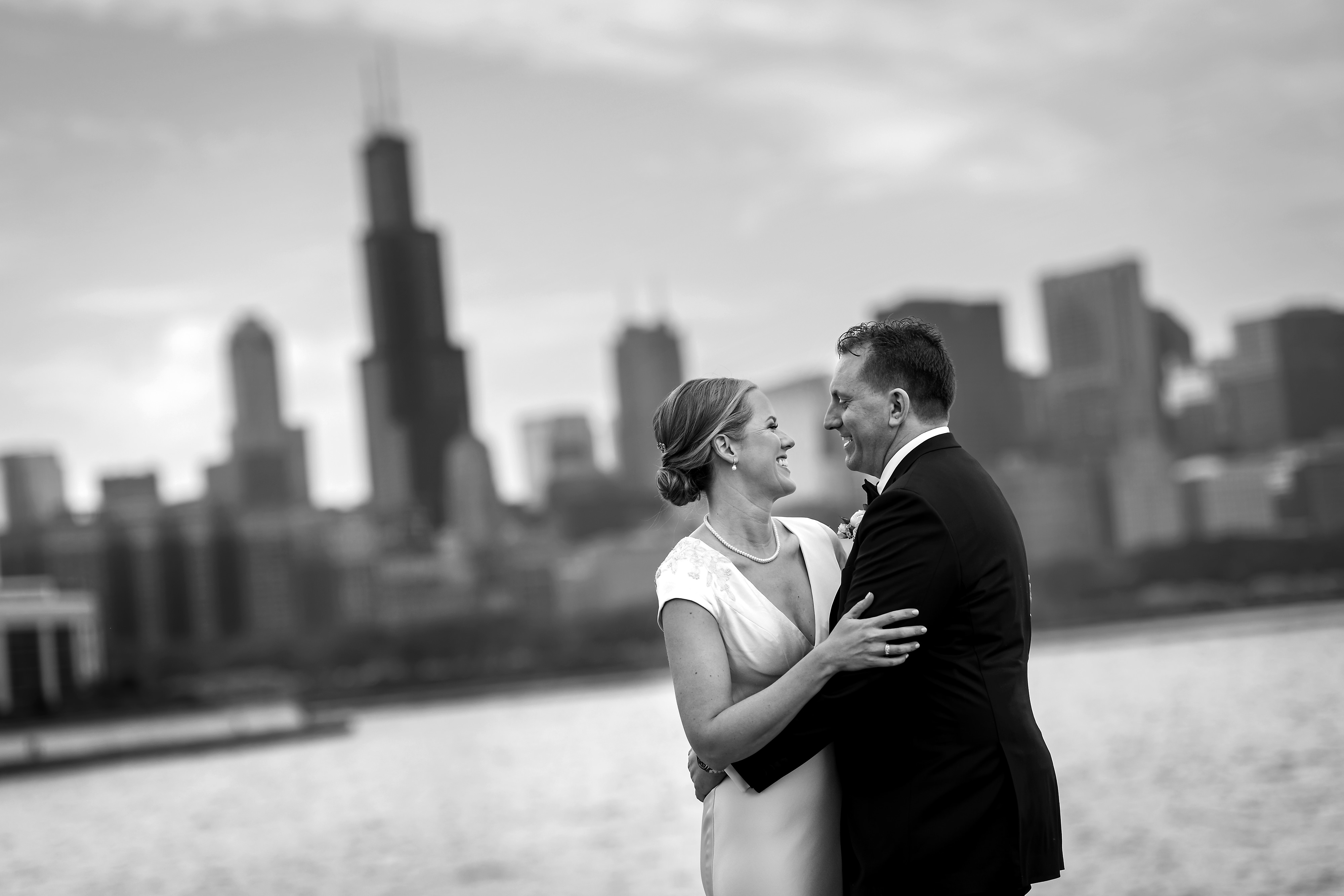 Bride and groom black and white photos with Sears Tower and Chicago Skyline from Museum Campus Adler Planetarium building