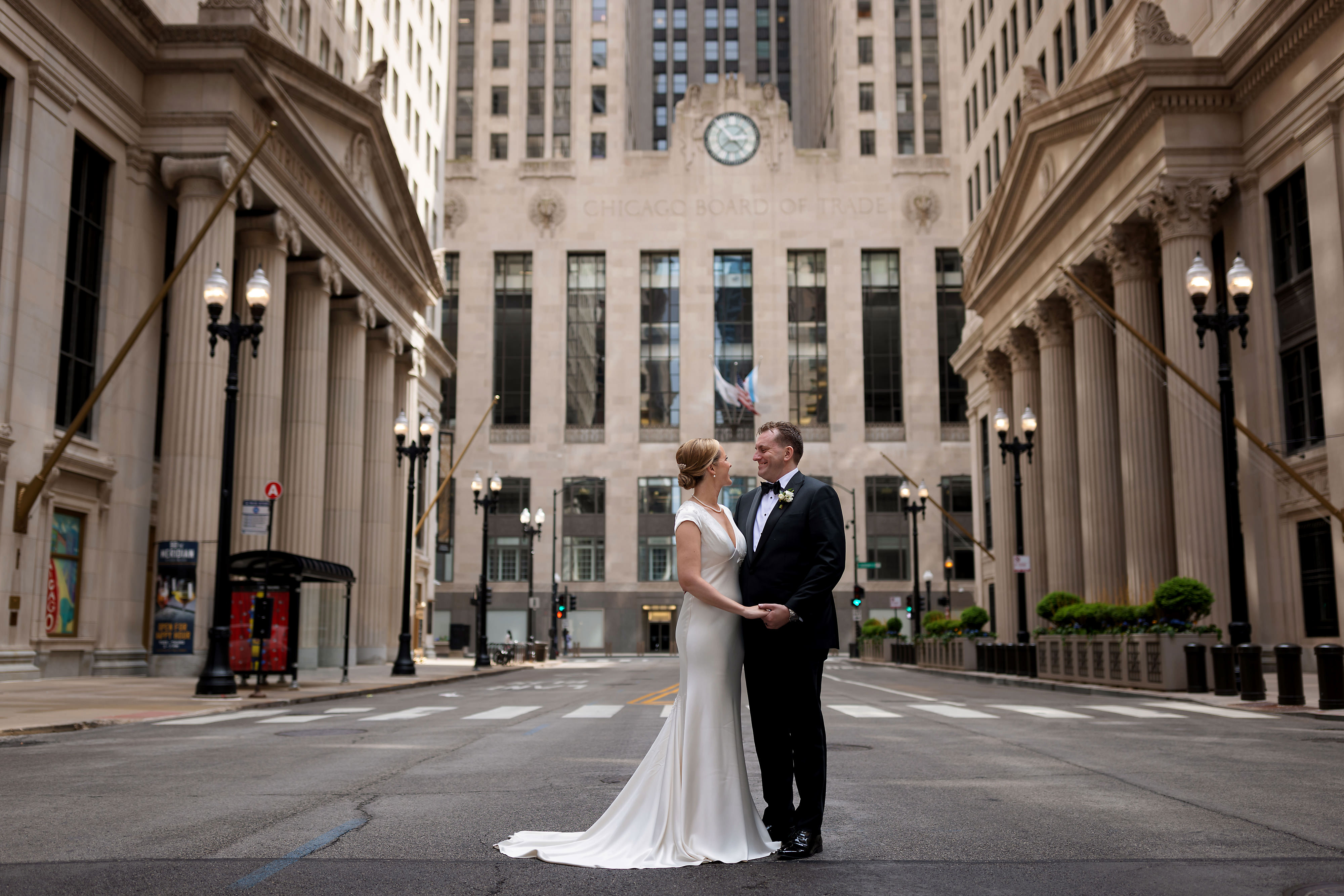 Couple stand in LaSalle Street in front of Chicago Board of Trade Building in downtown Chicago