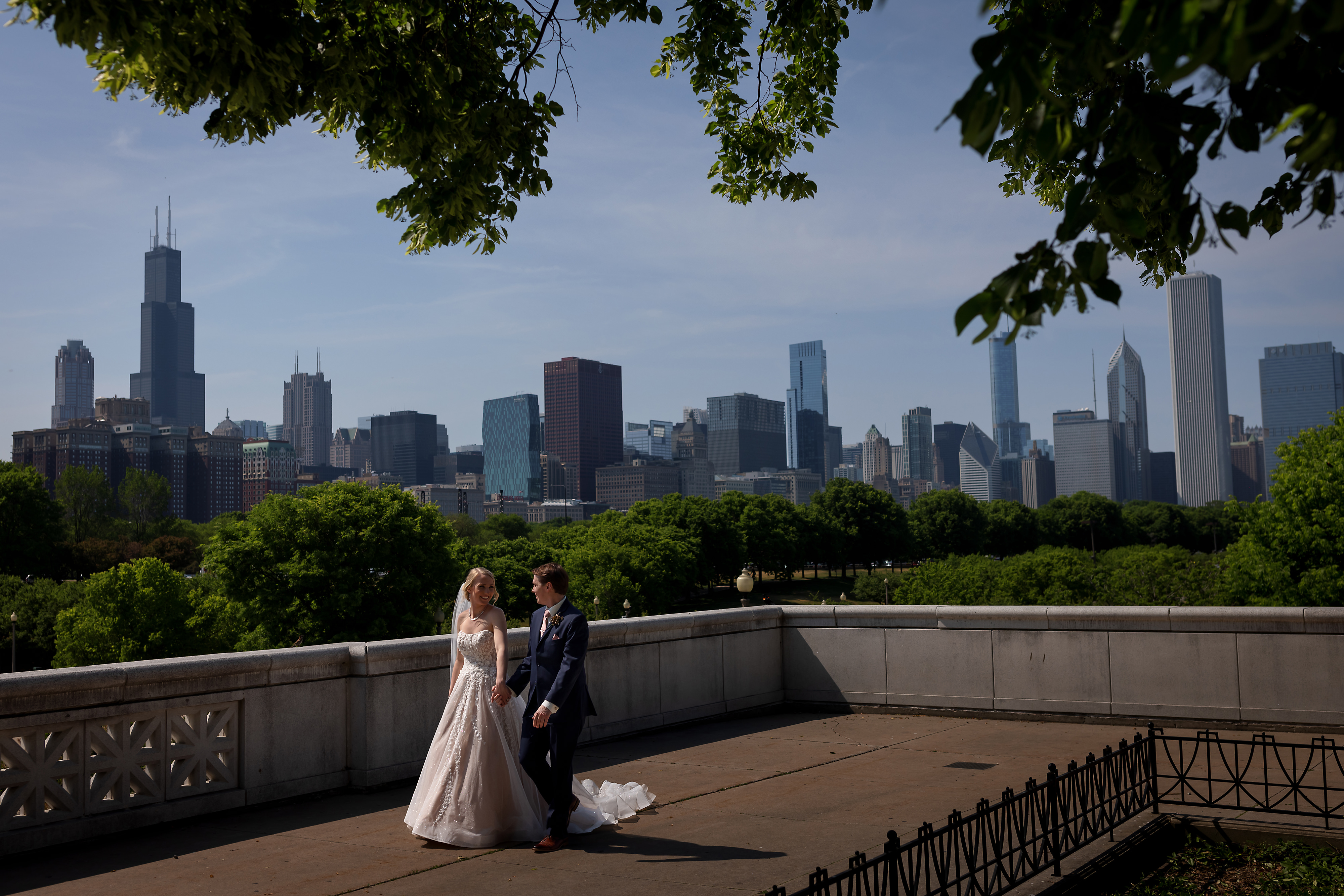 Bride and groom walk along museum campus during their wedding portraits