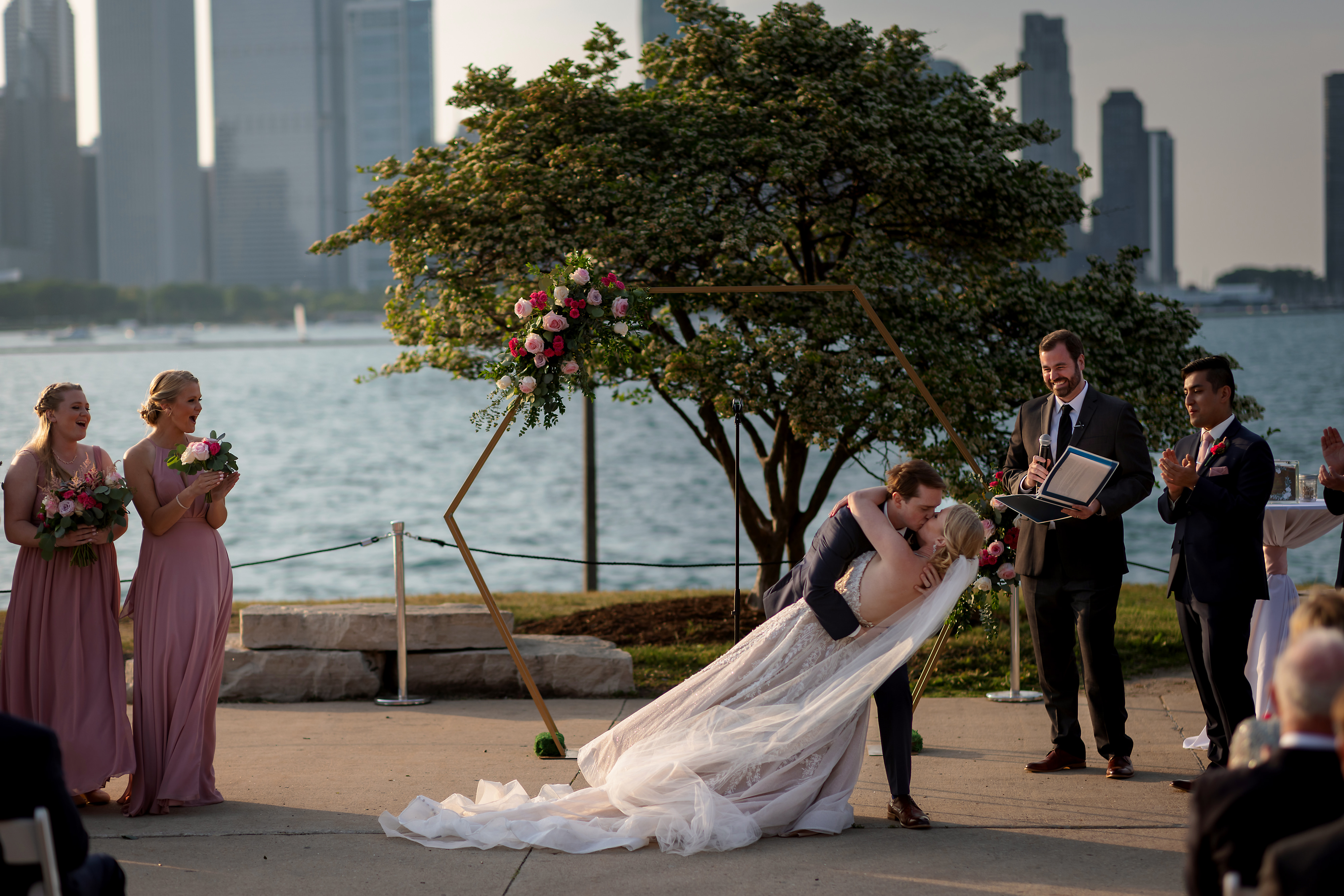 dip kiss at the end of outdoor wedding ceremony at Adler Planetarium in Chicago