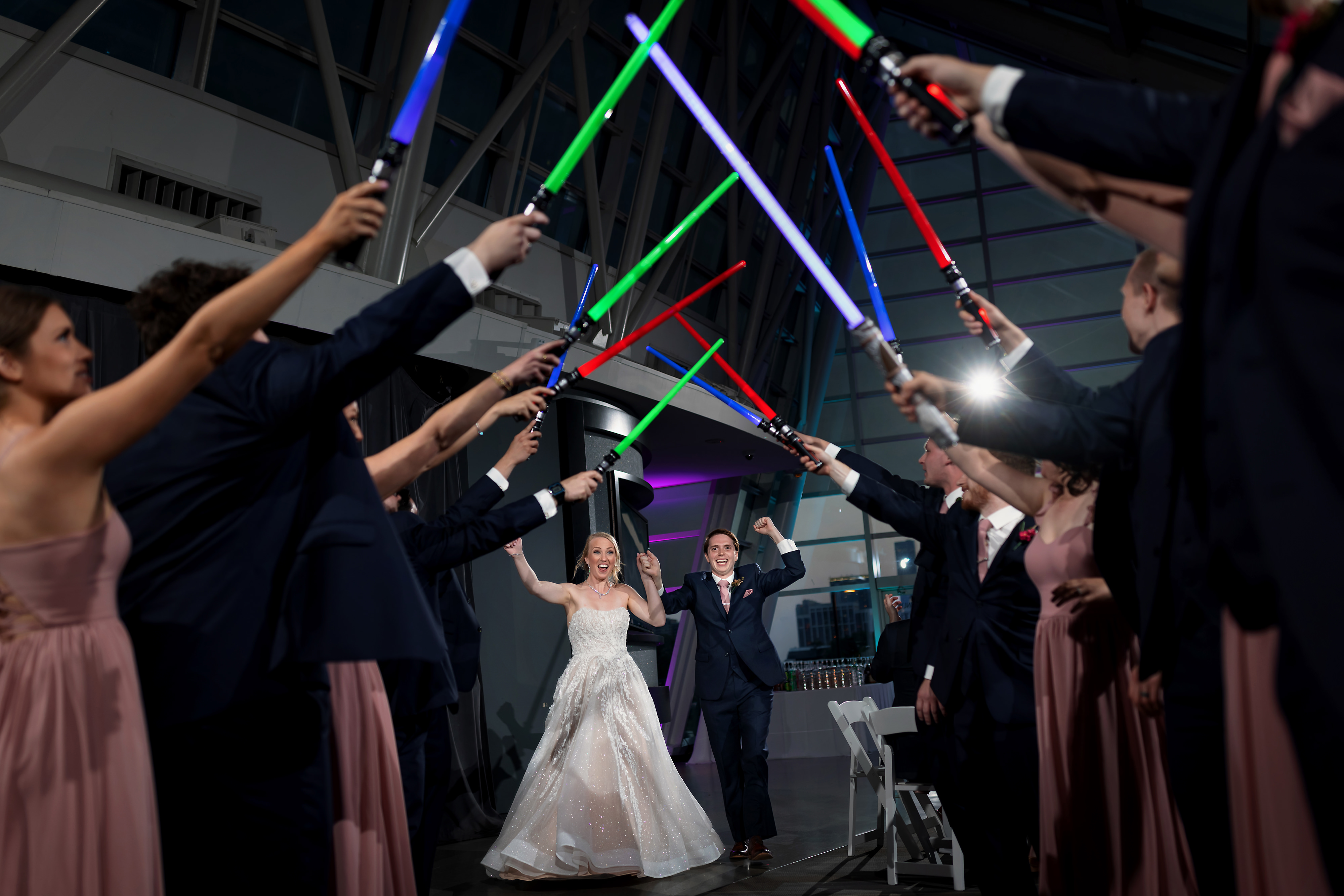bride and groom enter wedding reception under tunnel of lightsabers at Adler Planetarium in Chicago