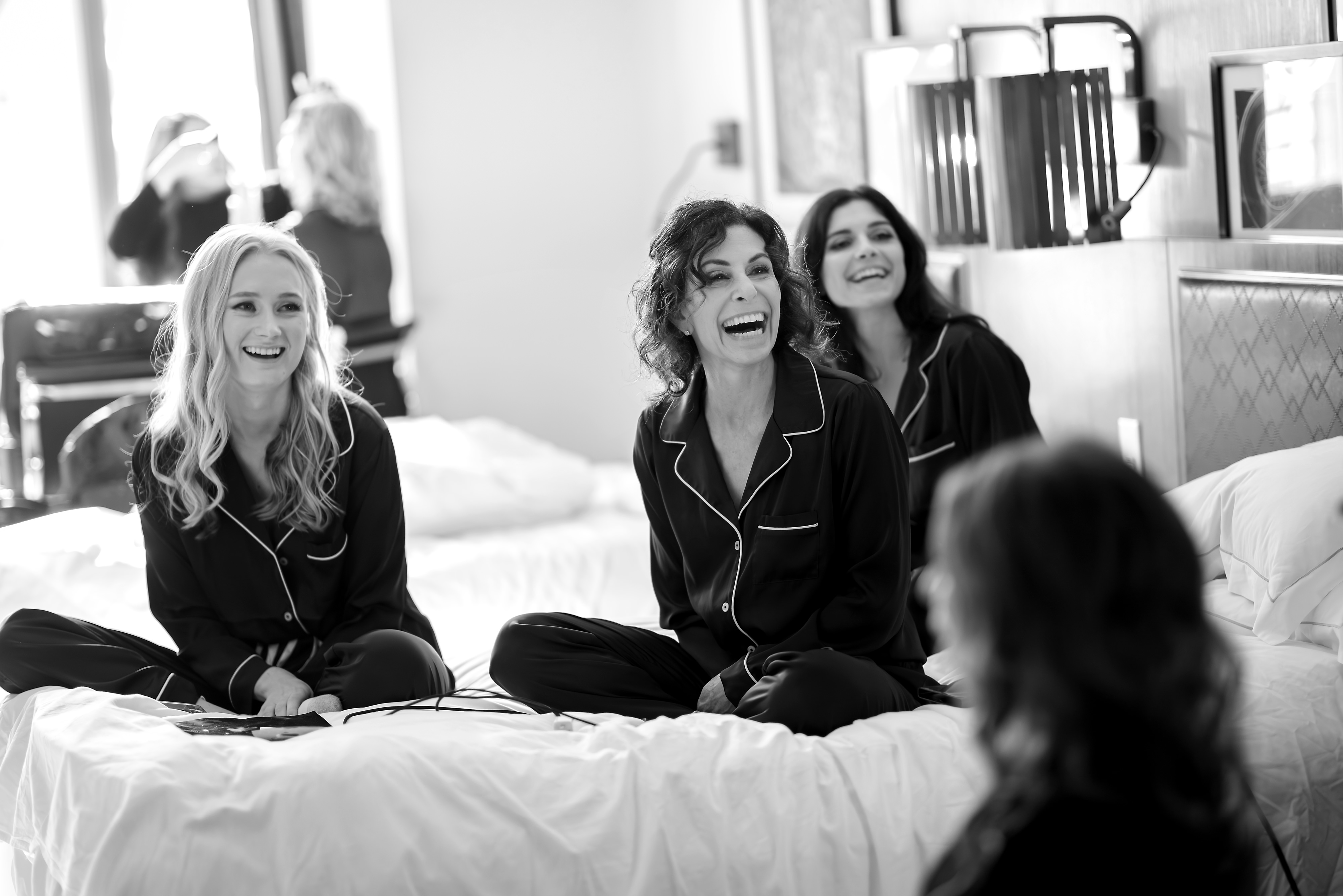 Bridesmaids getting ready on bed