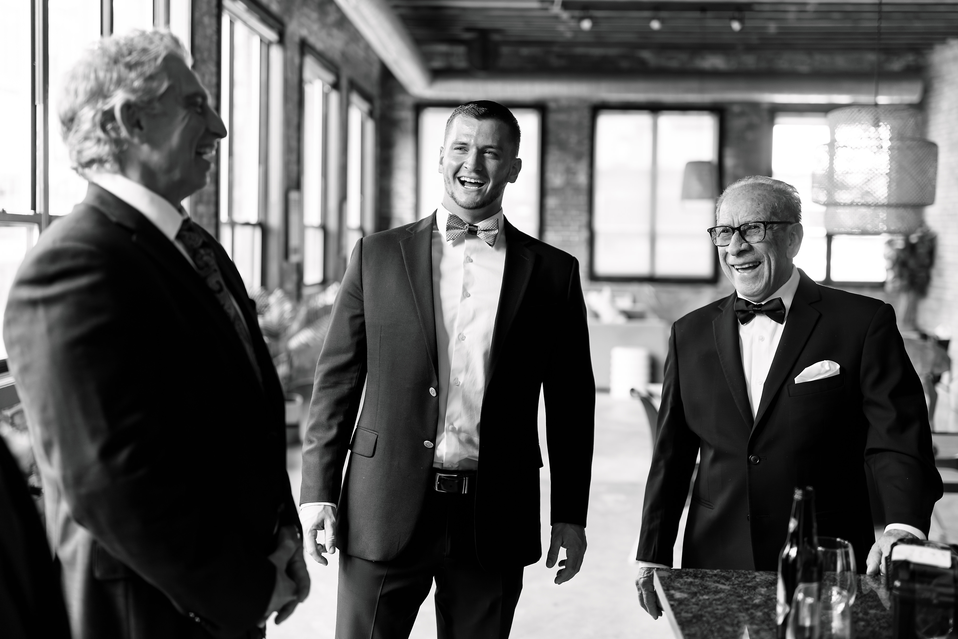 Groomsman and grandfather laughing together