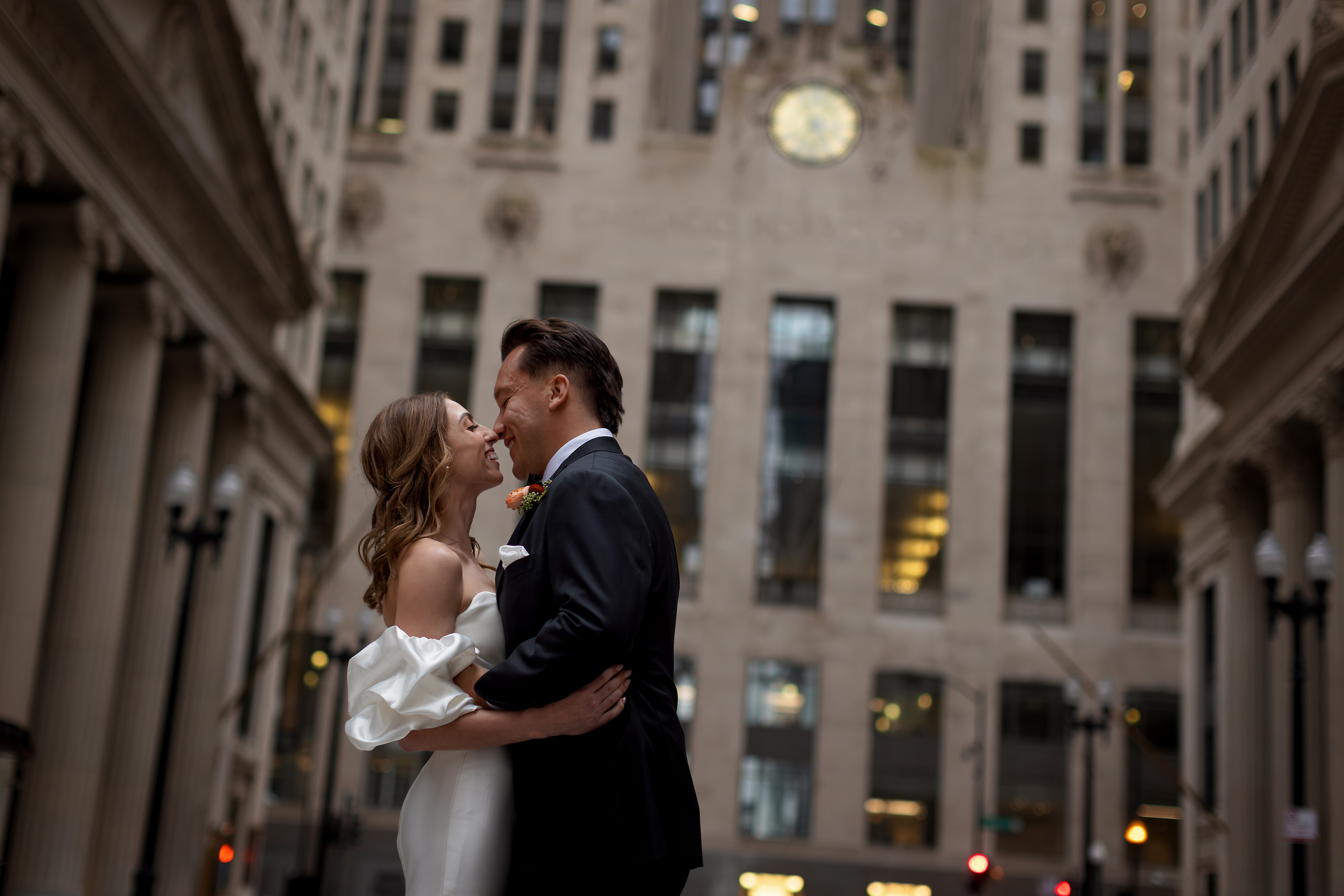 Portrait of Bride and Groom kissing in front of Board of Trade Building on LaSalle Street in Chicago