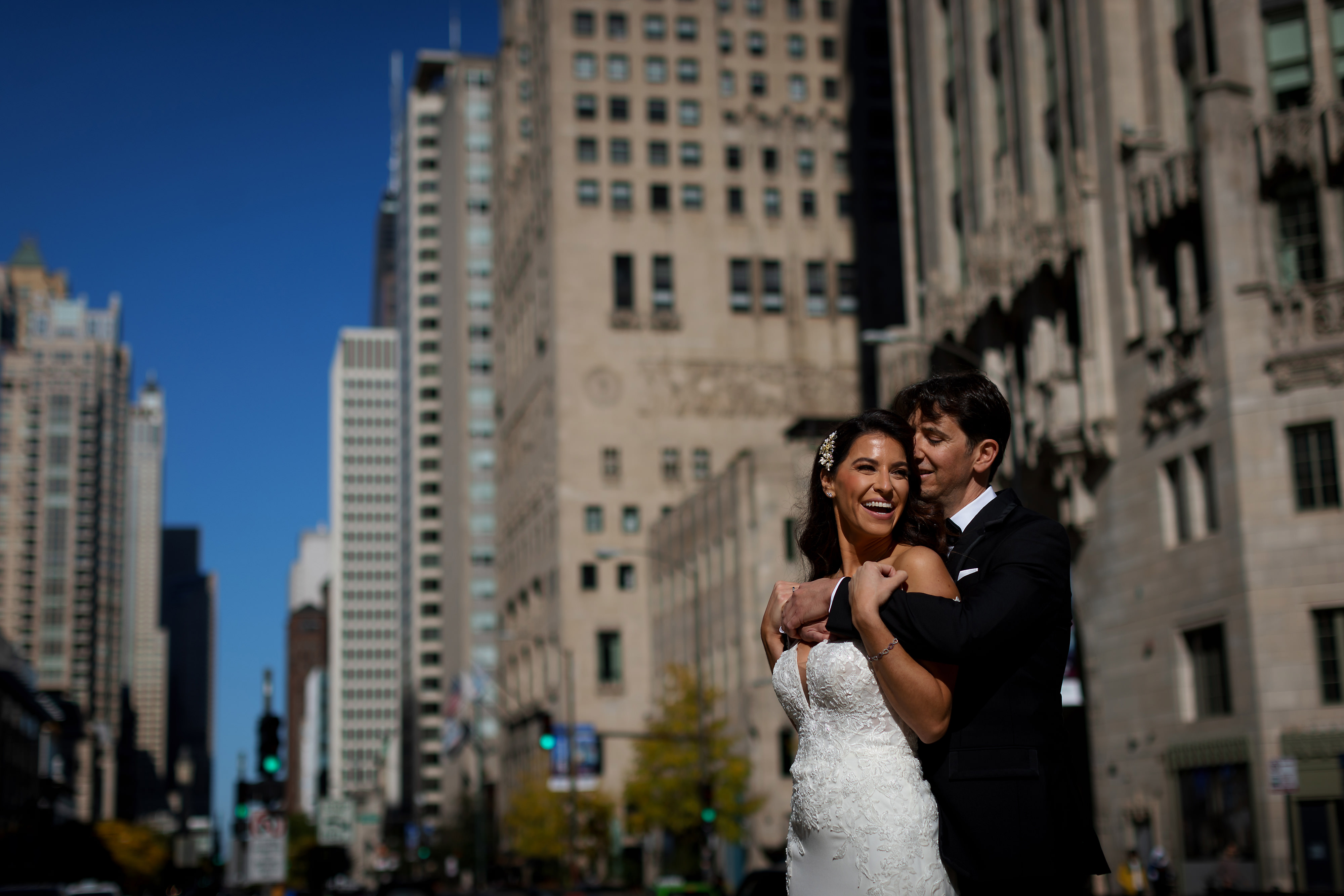 Bride and groom kiss outside the Wrigley Building with the Chicago River in the background