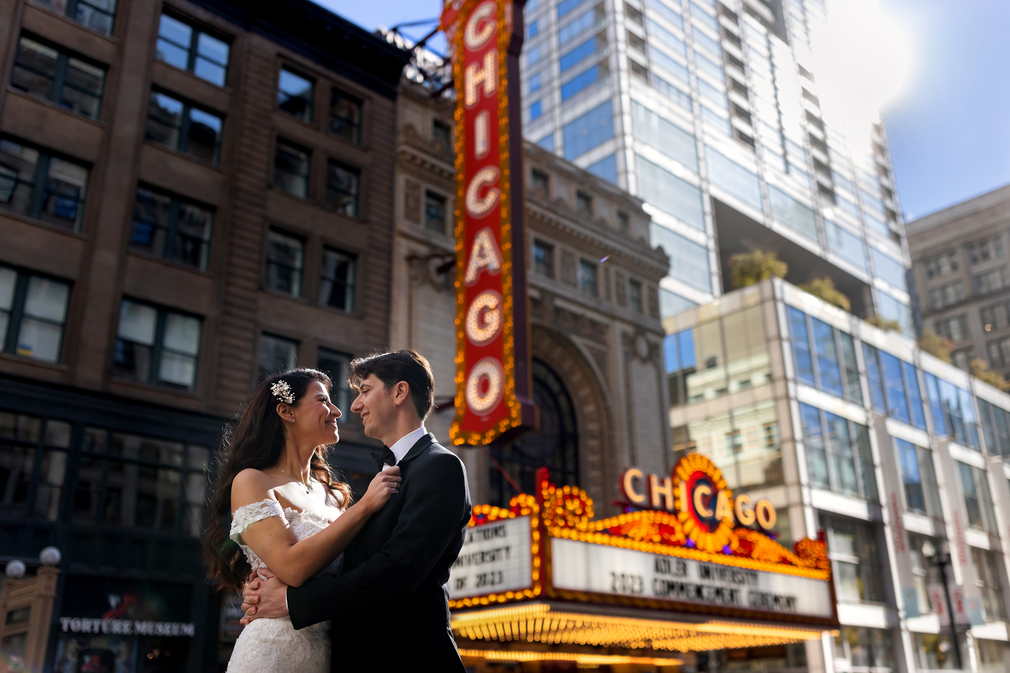 Bride and groom pose for photo in front of Chicago Theatre sign